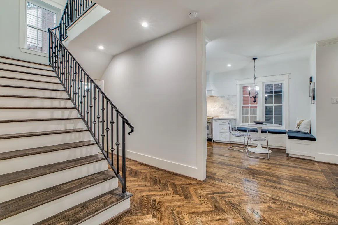 A large room with stairs and hardwood floors.