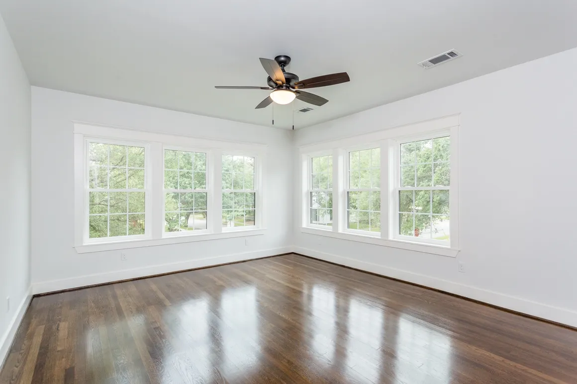 A room with many windows and a ceiling fan.