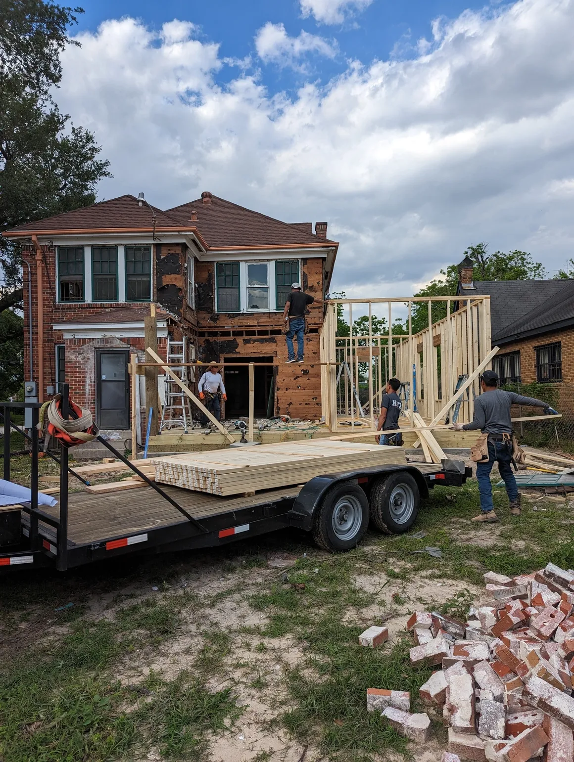 A trailer is being loaded with wood and concrete.