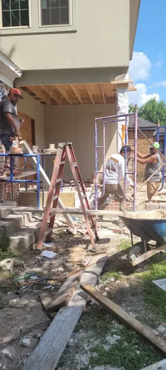 A group of people working on the outside of a house.