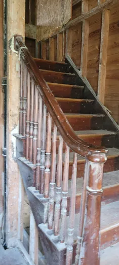A wooden staircase with metal railing and wood handrail.